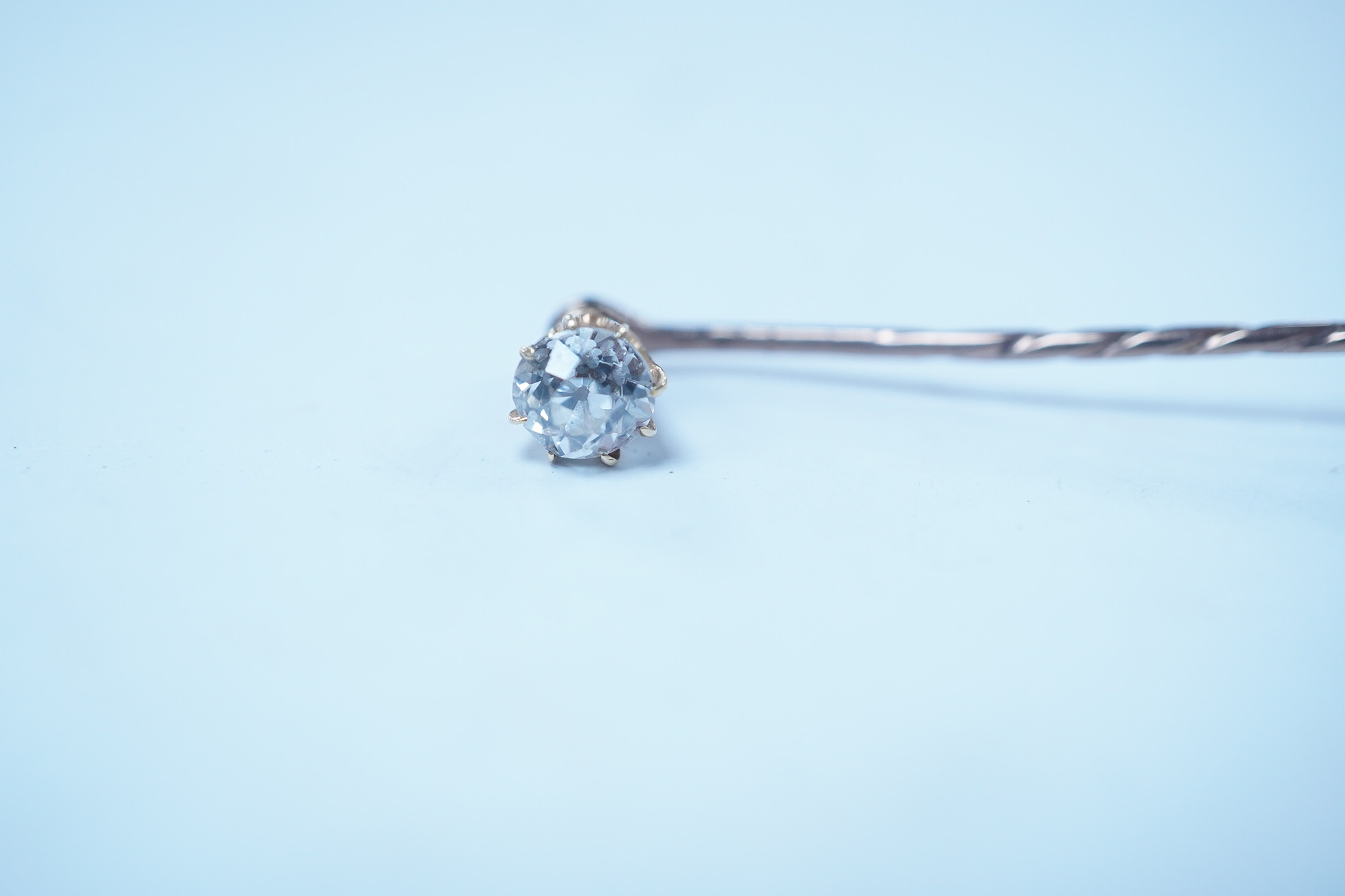 A yellow metal and solitaire diamond set stick pin, the stone diameter approx. 5mm, 59mm, gross weight 2.3 grams. Condition - fair to good